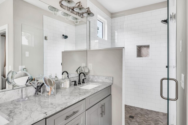 bathroom featuring vanity, a shower with door, and a healthy amount of sunlight