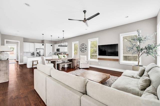 living room with ceiling fan and dark hardwood / wood-style flooring