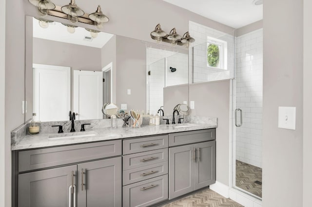 bathroom featuring a shower with door and vanity