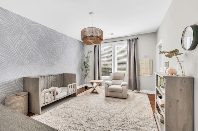 bedroom featuring hardwood / wood-style flooring and a crib