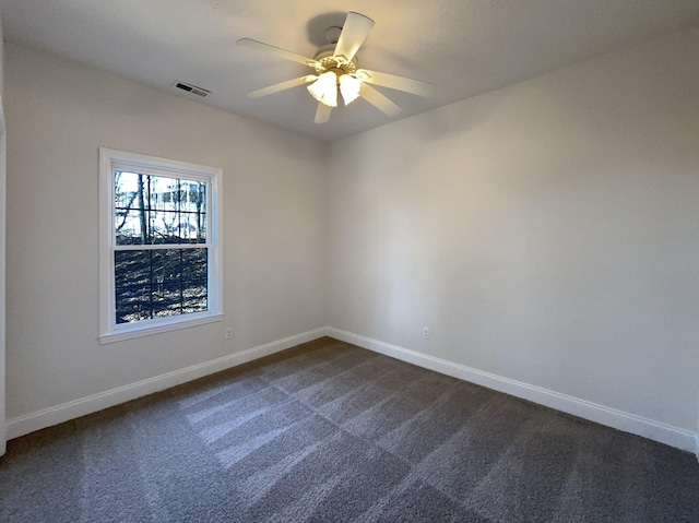 empty room with dark carpet and ceiling fan