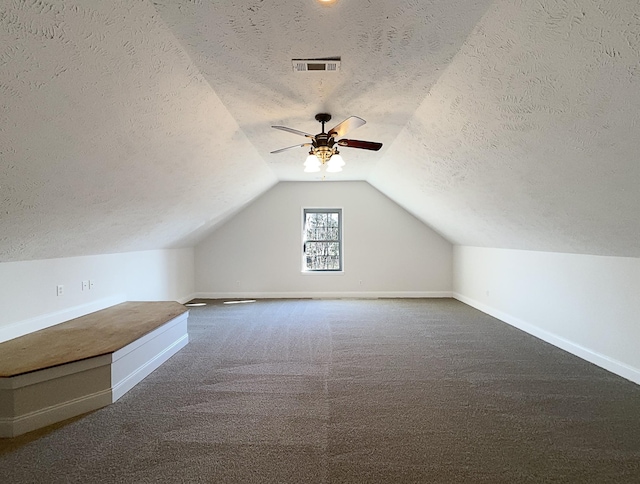 bonus room featuring ceiling fan, carpet, lofted ceiling, and a textured ceiling