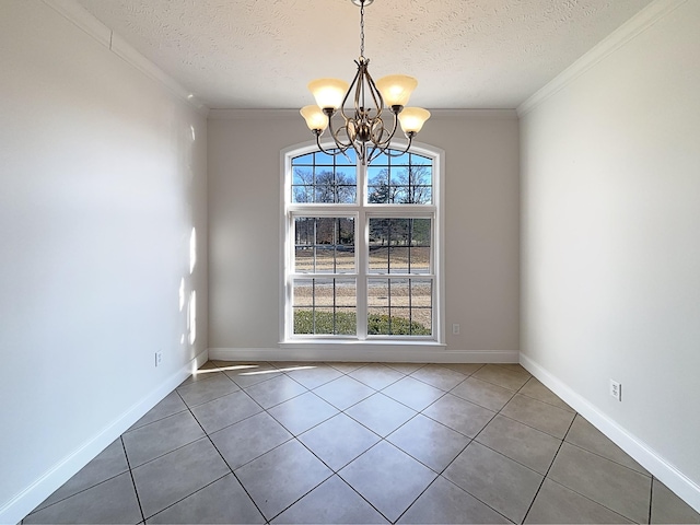 empty room with an inviting chandelier, ornamental molding, dark tile patterned flooring, and a textured ceiling