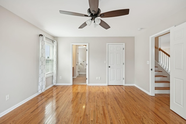 unfurnished bedroom with ceiling fan, ensuite bathroom, and light hardwood / wood-style flooring