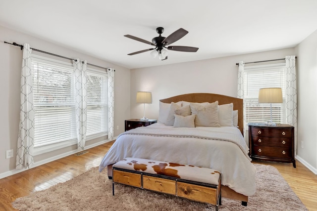 bedroom featuring multiple windows, ceiling fan, and light wood-type flooring