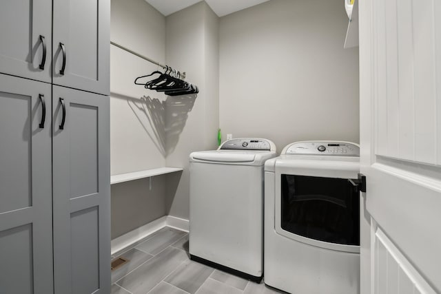 washroom featuring cabinets and washer and clothes dryer