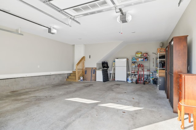 garage with white refrigerator and a garage door opener