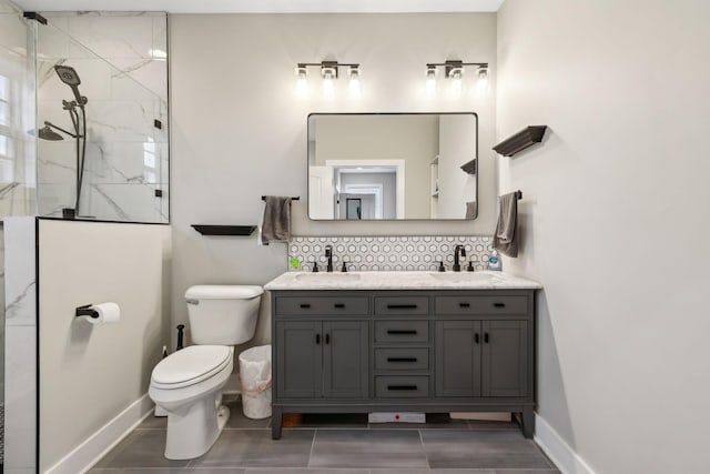 bathroom with vanity, backsplash, toilet, and a tile shower