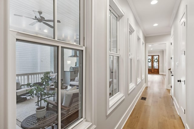 corridor featuring crown molding and light hardwood / wood-style floors