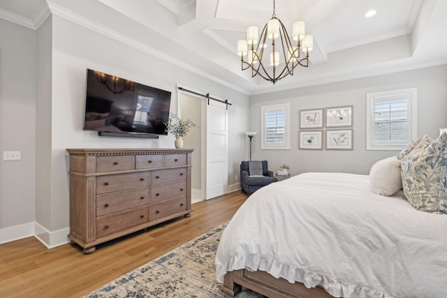 bedroom featuring multiple windows, hardwood / wood-style flooring, ornamental molding, and a barn door