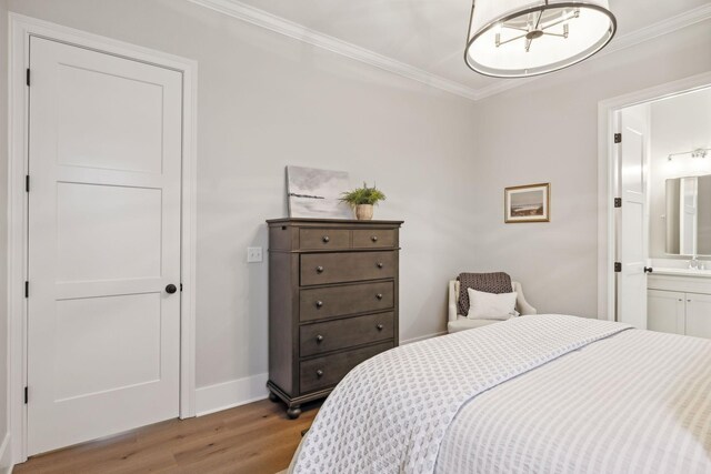 bedroom with ornamental molding, ensuite bathroom, sink, and light wood-type flooring