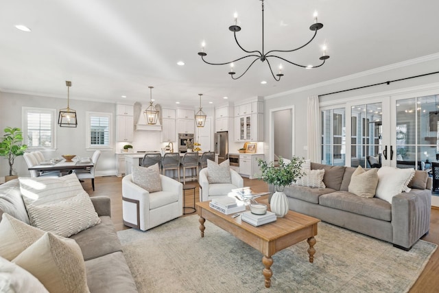 living room with ornamental molding, french doors, and light wood-type flooring