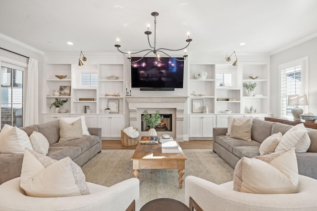 living room with built in features, ornamental molding, and light hardwood / wood-style flooring