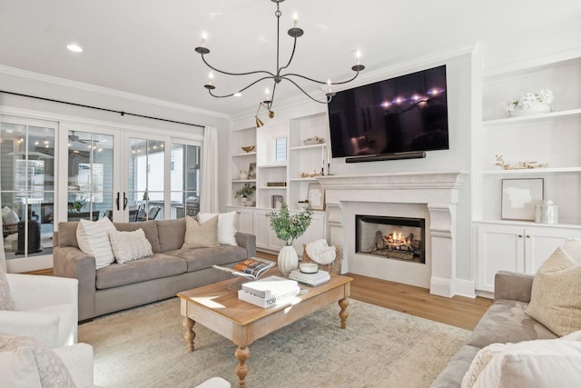 living room with crown molding, built in features, and light wood-type flooring