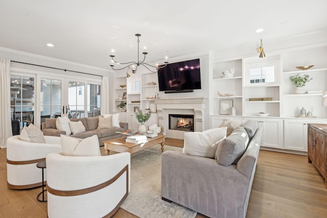 living room with ornamental molding, a chandelier, and light wood-type flooring