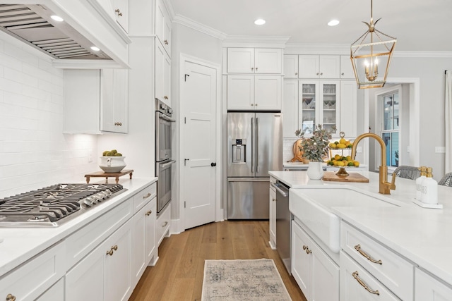 kitchen featuring sink, custom exhaust hood, white cabinetry, ornamental molding, and appliances with stainless steel finishes