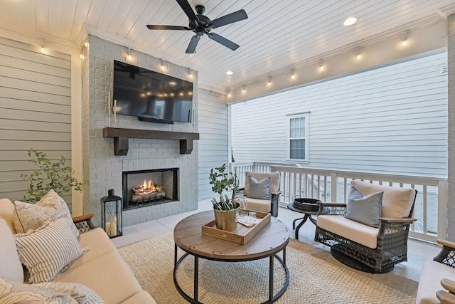 living room with an outdoor brick fireplace, wooden ceiling, ceiling fan, and wood walls