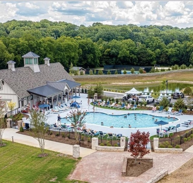 view of pool with a water view and a patio area