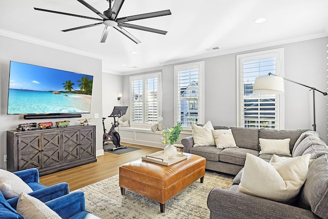 living room with crown molding, ceiling fan, and light wood-type flooring