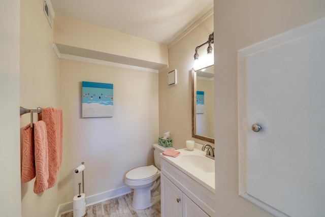 bathroom featuring hardwood / wood-style flooring, ornamental molding, vanity, and toilet