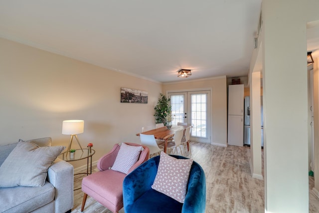 living room featuring crown molding, french doors, and light wood-type flooring