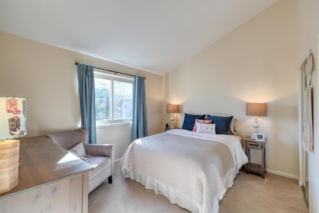 carpeted bedroom with lofted ceiling