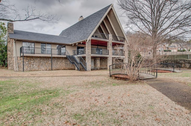 rear view of property with a balcony and a yard