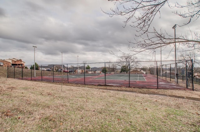 view of tennis court featuring a yard