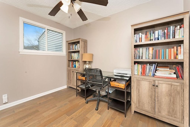 office space with ceiling fan, a textured ceiling, and light wood-type flooring