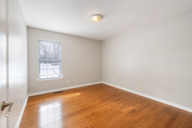 spare room featuring wood-type flooring