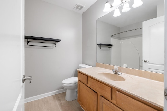 bathroom with vanity, hardwood / wood-style floors, toilet, and walk in shower