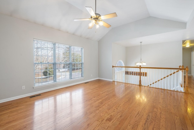 unfurnished room with ceiling fan with notable chandelier, wood-type flooring, and vaulted ceiling