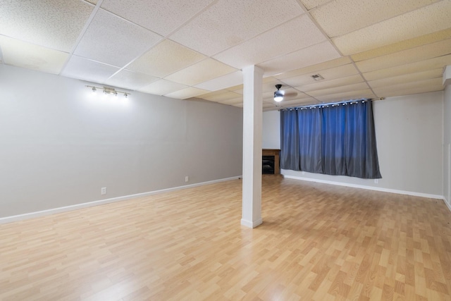 basement with a drop ceiling and wood-type flooring