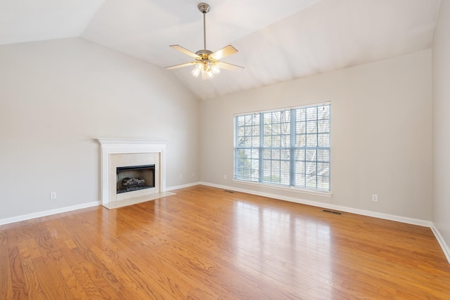 unfurnished living room featuring a premium fireplace, ceiling fan, lofted ceiling, and light hardwood / wood-style floors