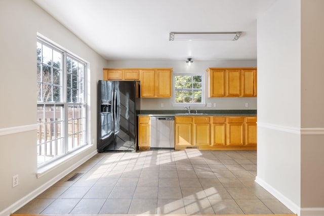 kitchen with light tile patterned flooring, dishwasher, sink, and black fridge with ice dispenser