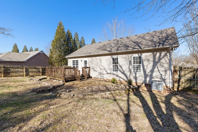 rear view of house featuring a wooden deck, a yard, and central AC