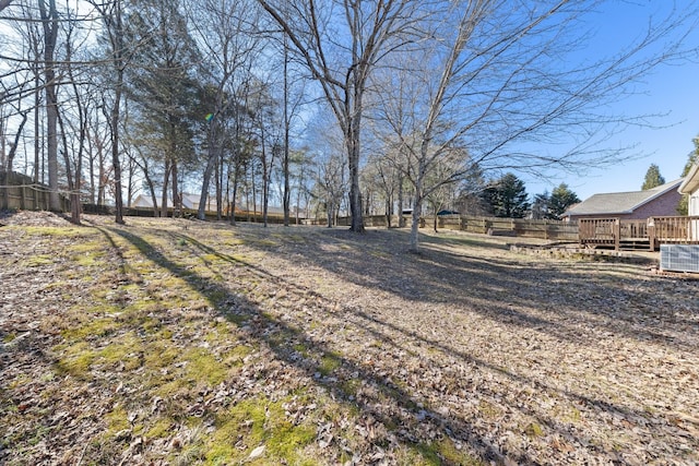 view of yard with a wooden deck and central air condition unit