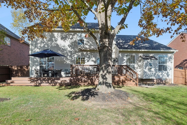 rear view of property featuring a wooden deck and a yard