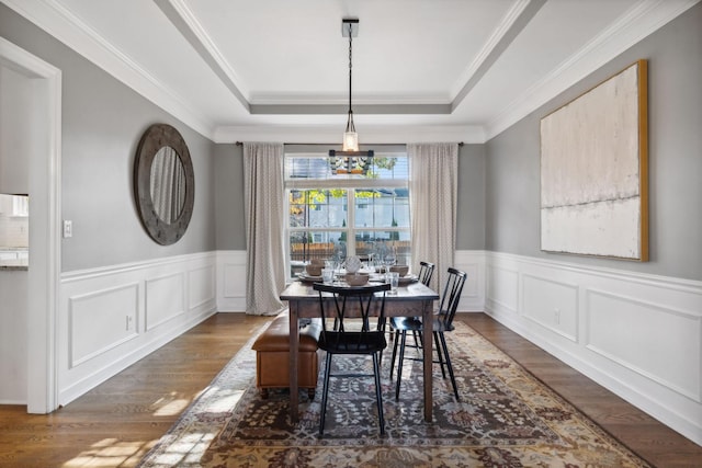 dining room featuring crown molding, dark hardwood / wood-style floors, a notable chandelier, and a tray ceiling