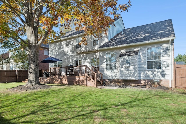 rear view of property with a wooden deck and a lawn