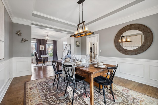 dining space featuring ornamental molding, dark hardwood / wood-style flooring, and a raised ceiling