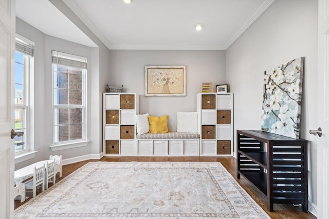 living area with crown molding, a healthy amount of sunlight, and dark hardwood / wood-style flooring