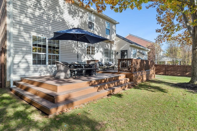 back of property with a wooden deck and a yard