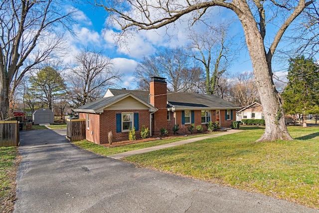 single story home with a storage shed and a front yard