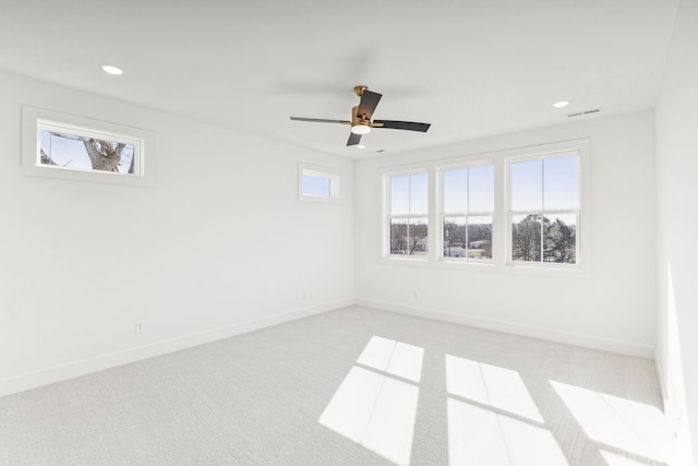 carpeted spare room with a healthy amount of sunlight and ceiling fan