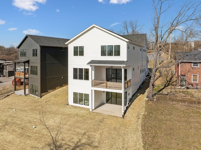 back of house featuring a patio area, a balcony, and a lawn