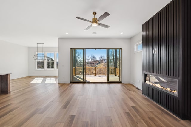 unfurnished living room featuring wood-type flooring and ceiling fan