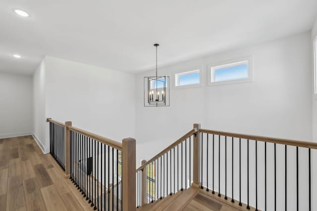 hall featuring hardwood / wood-style floors and a chandelier