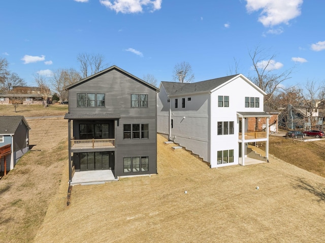 rear view of house featuring a balcony and a patio area