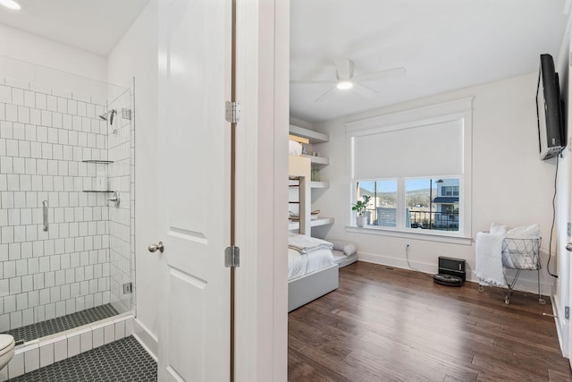 bathroom with ceiling fan, an enclosed shower, and hardwood / wood-style floors